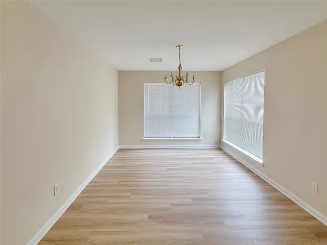 a view of empty room with wooden floor and window