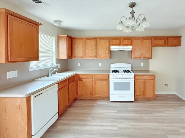 a kitchen with a stove a sink and a window