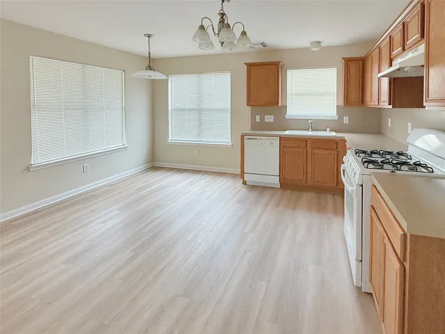 a kitchen with stainless steel appliances granite countertop a sink cabinets and wooden floor