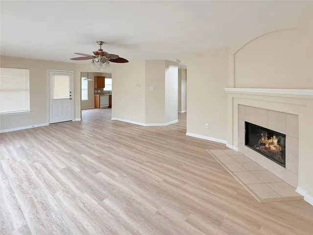 a view of an empty room with a fireplace and a window