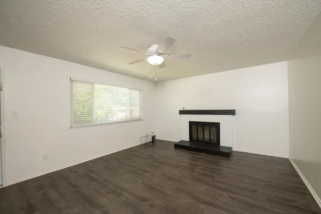 an empty room with a fireplace and wooden floor