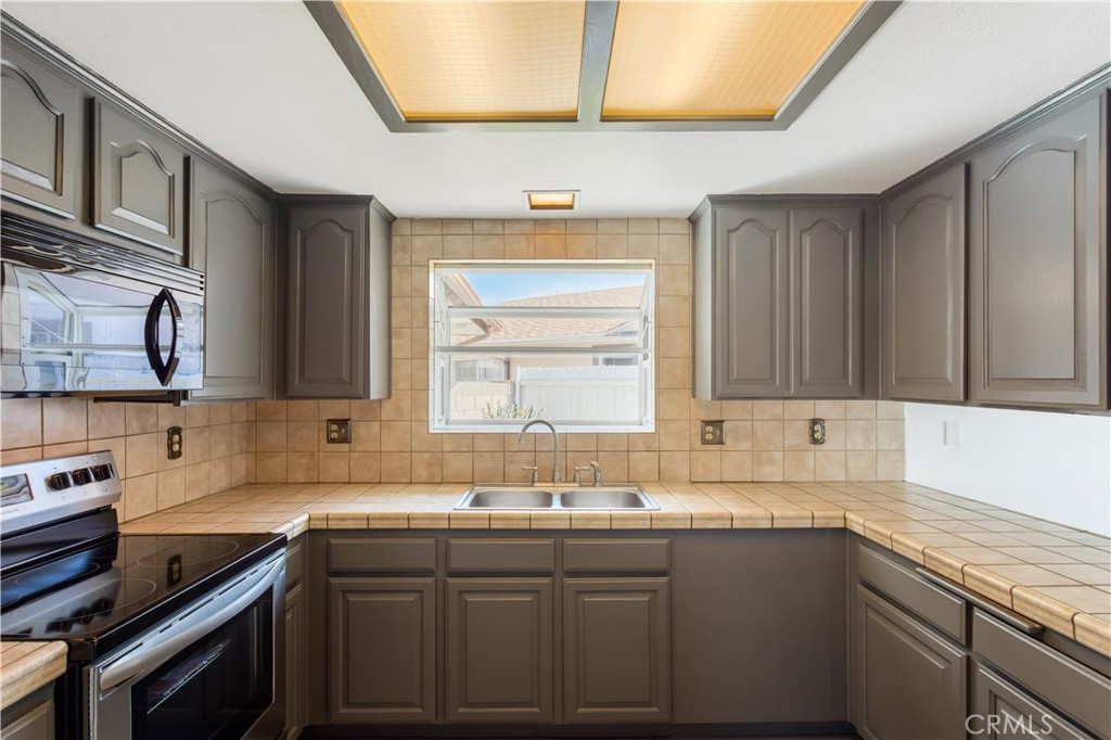 2348 Los Altos Circle Hemet, CA 92545 - Photo 12 of 35 a kitchen with a sink stove and cabinets