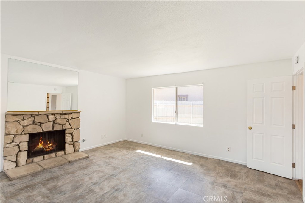 2348 Los Altos Circle Hemet, CA 92545 - Photo 20 of 35 an empty room with a fireplace and window