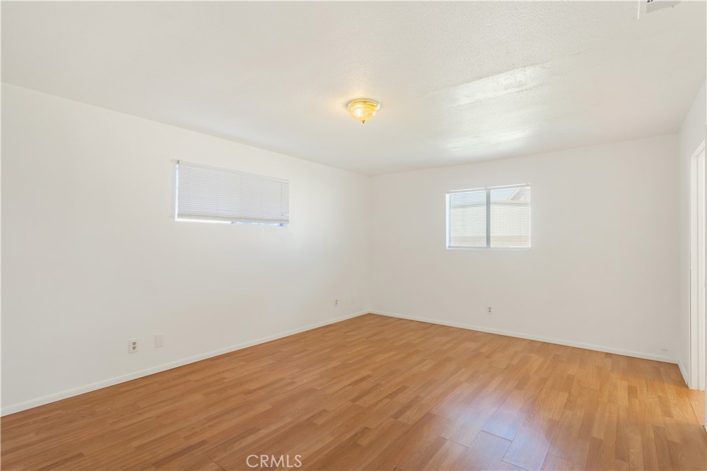 2348 Los Altos Circle Hemet, CA 92545 - Photo 32 of 35 an empty room with wooden floor and windows