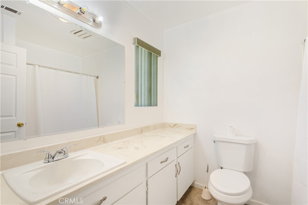2348 Los Altos Circle Hemet, CA 92545 - Photo 34 of 35 a bathroom with a sink a toilet and mirror