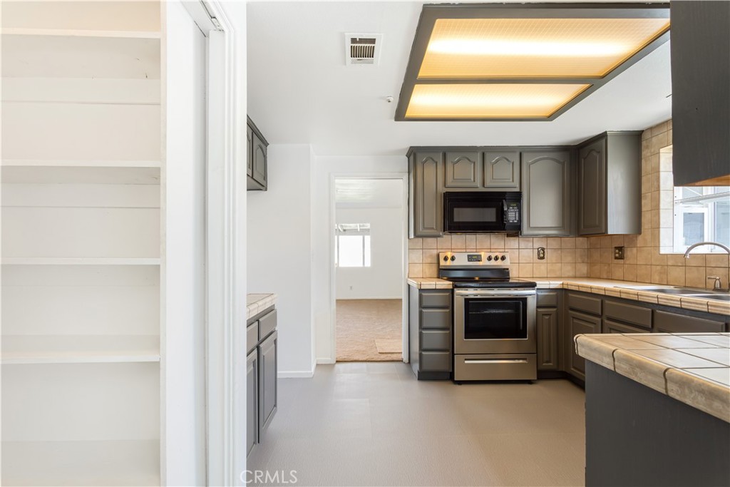 2348 Los Altos Circle Hemet, CA 92545 - Photo 9 of 35 a kitchen with stainless steel appliances granite countertop a stove and a refrigerator