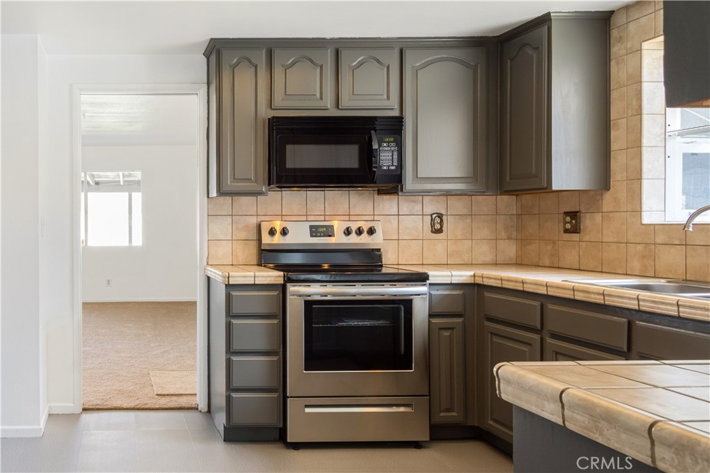 2348 Los Altos Circle Hemet, CA 92545 - Photo 10 of 35 a kitchen with stainless steel appliances a stove microwave and sink