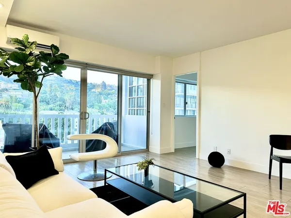 a living room with furniture and a floor to ceiling window