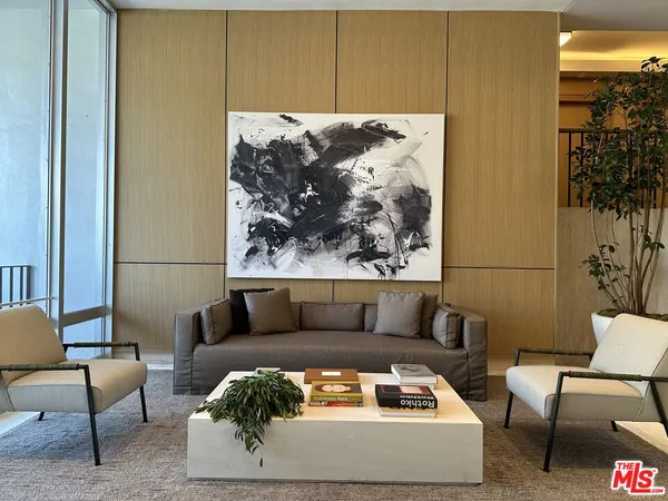 a living room with furniture and a painting on the wall