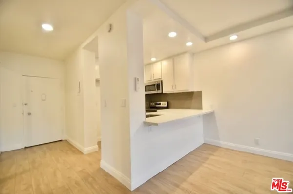 a view of kitchen with stainless steel appliances cabinets and wooden floor