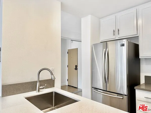 a kitchen with stainless steel appliances a refrigerator sink and cabinets