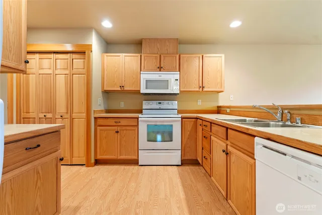 a kitchen with a refrigerator a stove top oven a sink and cabinets