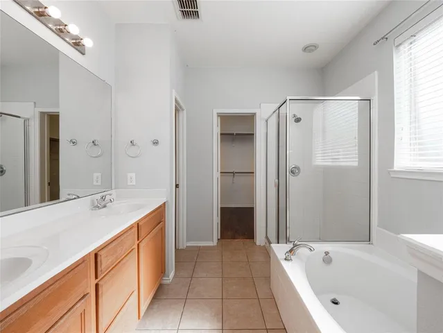 a spacious bathroom with a tub sink and mirror