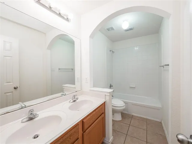a bathroom with a double vanity sink toilet and shower