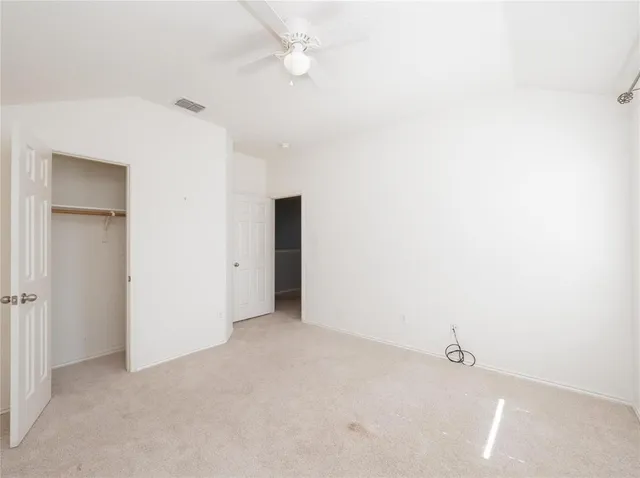 an empty room with a ceiling fan and a window