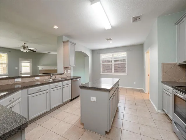 a kitchen with granite countertop a sink and a stove