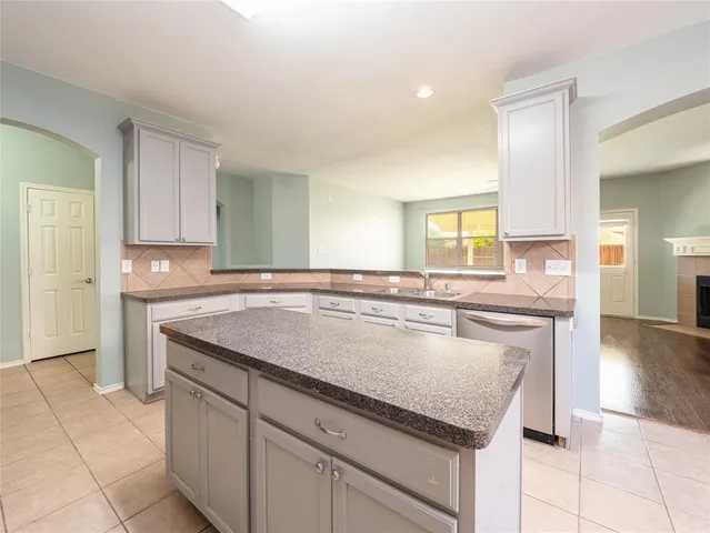 a kitchen with granite countertop a sink and cabinets