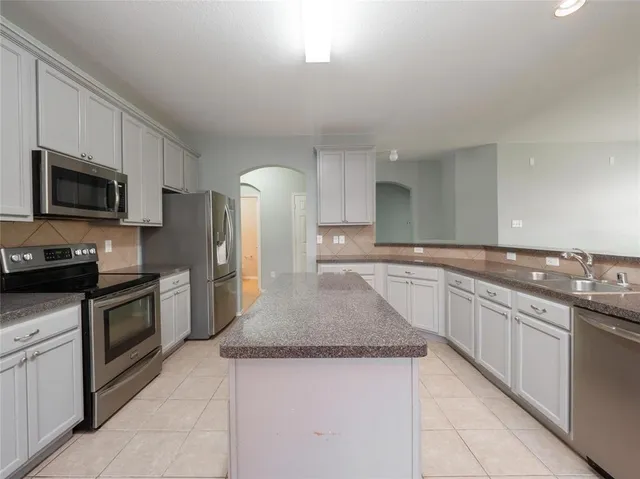 a kitchen with stainless steel appliances granite countertop a sink and stove top oven