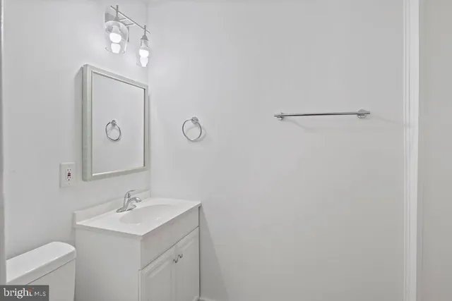 a bathroom with a sink a light fixture and a toilet