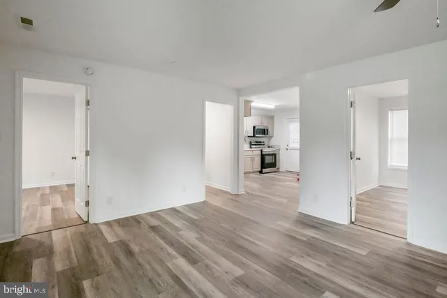 a view of empty room with wooden floor