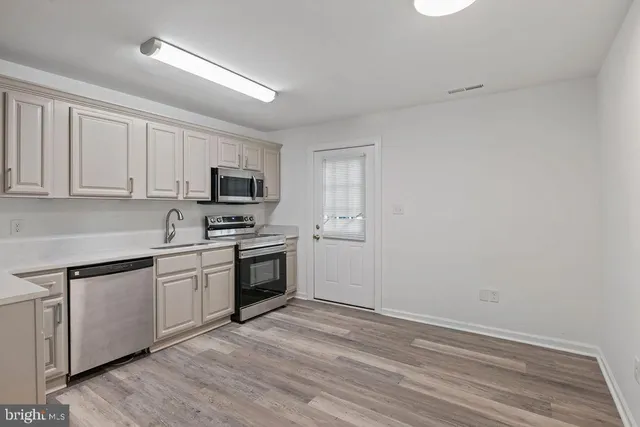 a kitchen with granite countertop white cabinets and stainless steel appliances