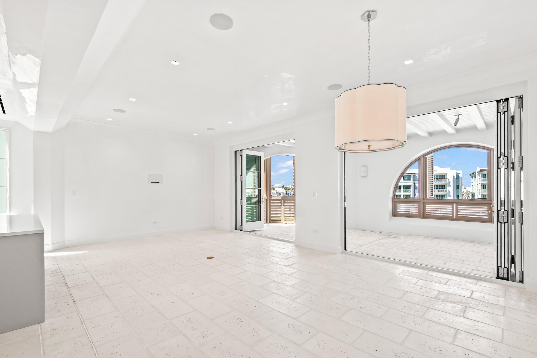 a view of an empty room and a chandelier fan