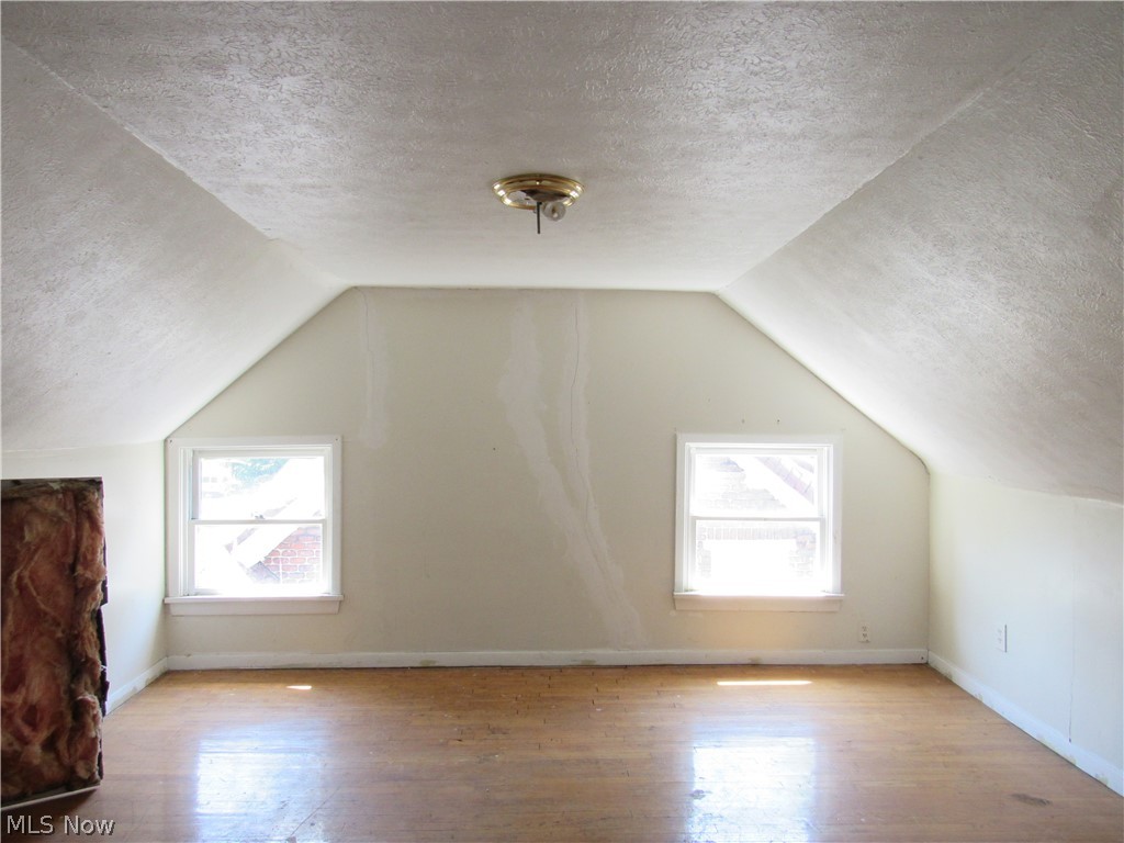1726 Lee Road Cleveland Heights, OH 44118 - Photo 30 of 36 Attic space featuring wood-finish flooring, white walls, and a sloped ceiling