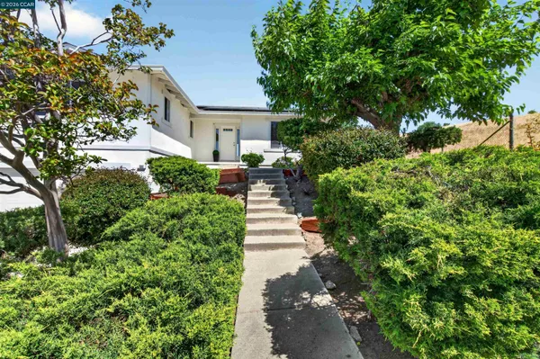a front view of a house with a yard and fountain in middle