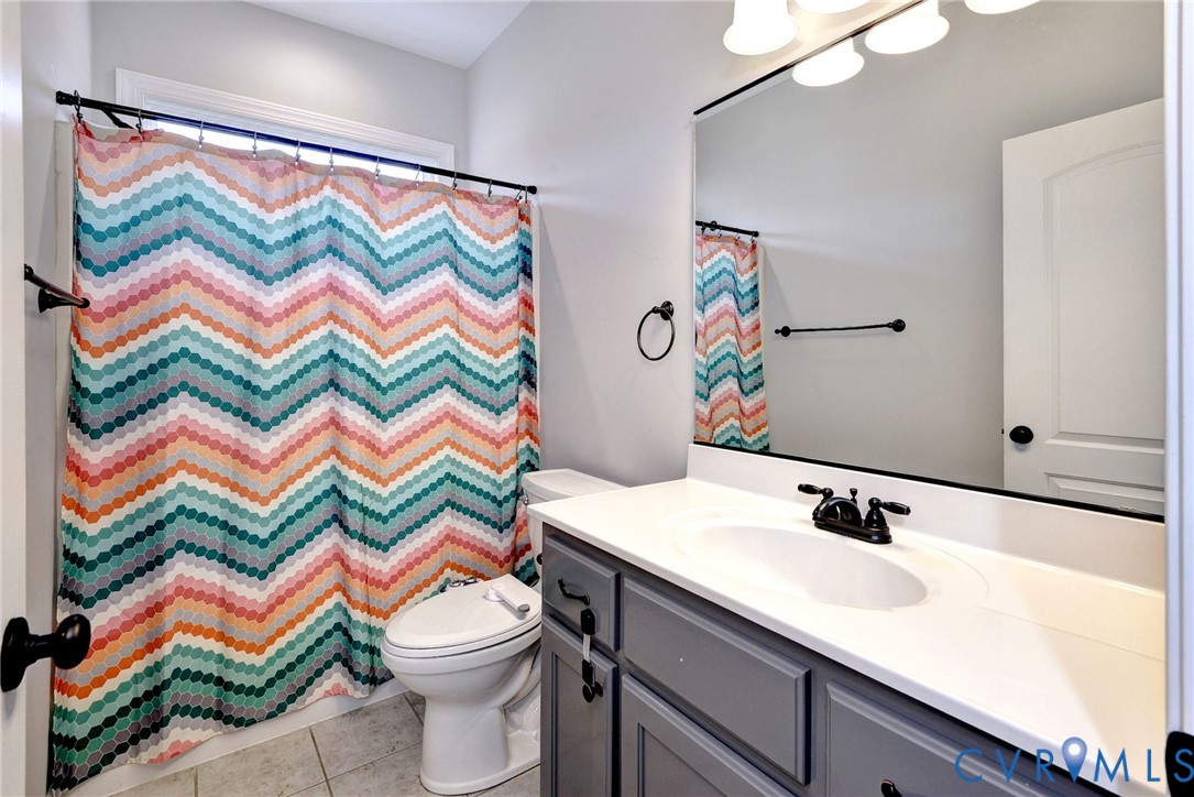 8904 Rock Cedar Road New Kent, VA 23124 - Photo 20 of 37 a bathroom with a sink a toilet and a shower curtain