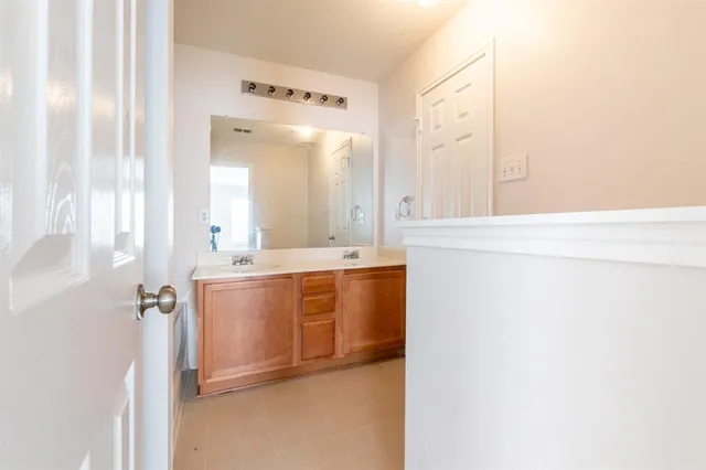 a bathroom with a double vanity sink and mirror
