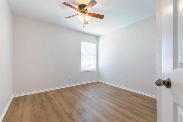 an empty room with a window and a fan