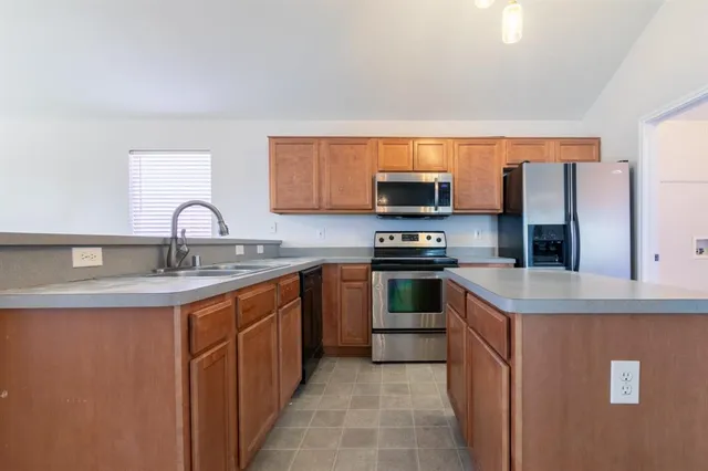 a kitchen with stainless steel appliances granite countertop a sink stove and refrigerator