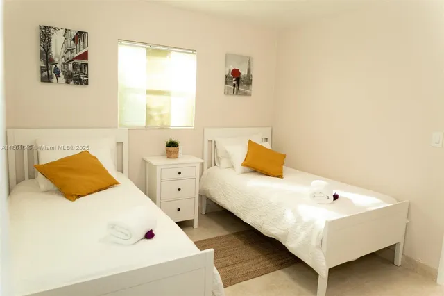 a bedroom with a bed a large window and a potted plant