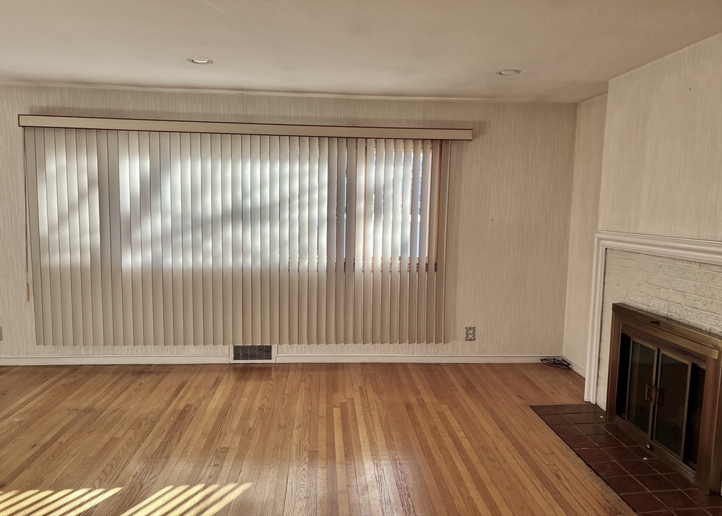 7 Ames Road Marblehead, MA 01945 - Photo 5 of 12 an empty room with wooden floor and fireplace