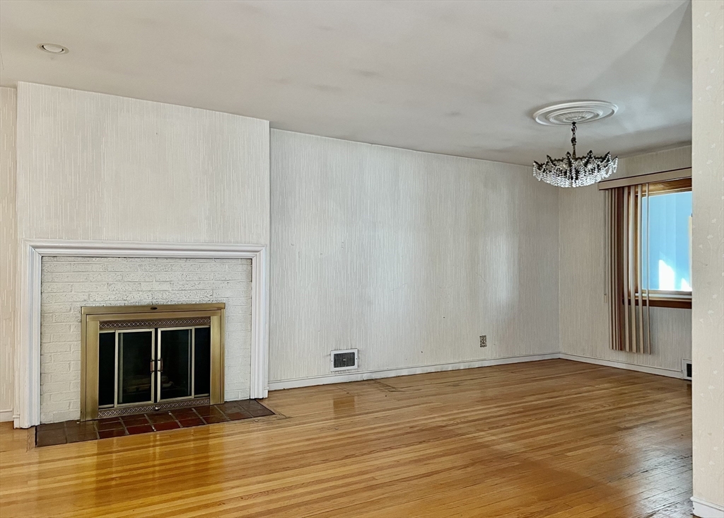 7 Ames Road Marblehead, MA 01945 - Photo 6 of 12 a view of an empty room with wooden floor and a fireplace