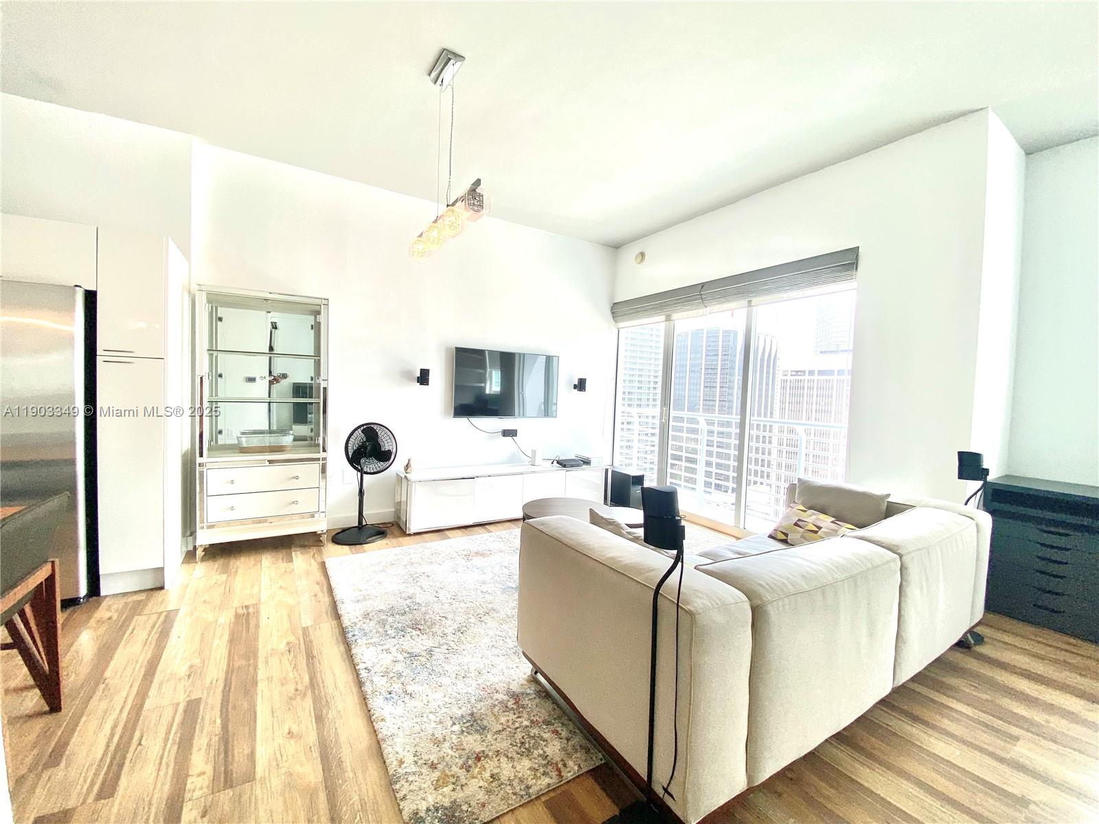 133 Northeast 2nd Avenue, Unit 2904 Miami, FL 33132 - Photo 2 of 11 a living room with furniture and a large window