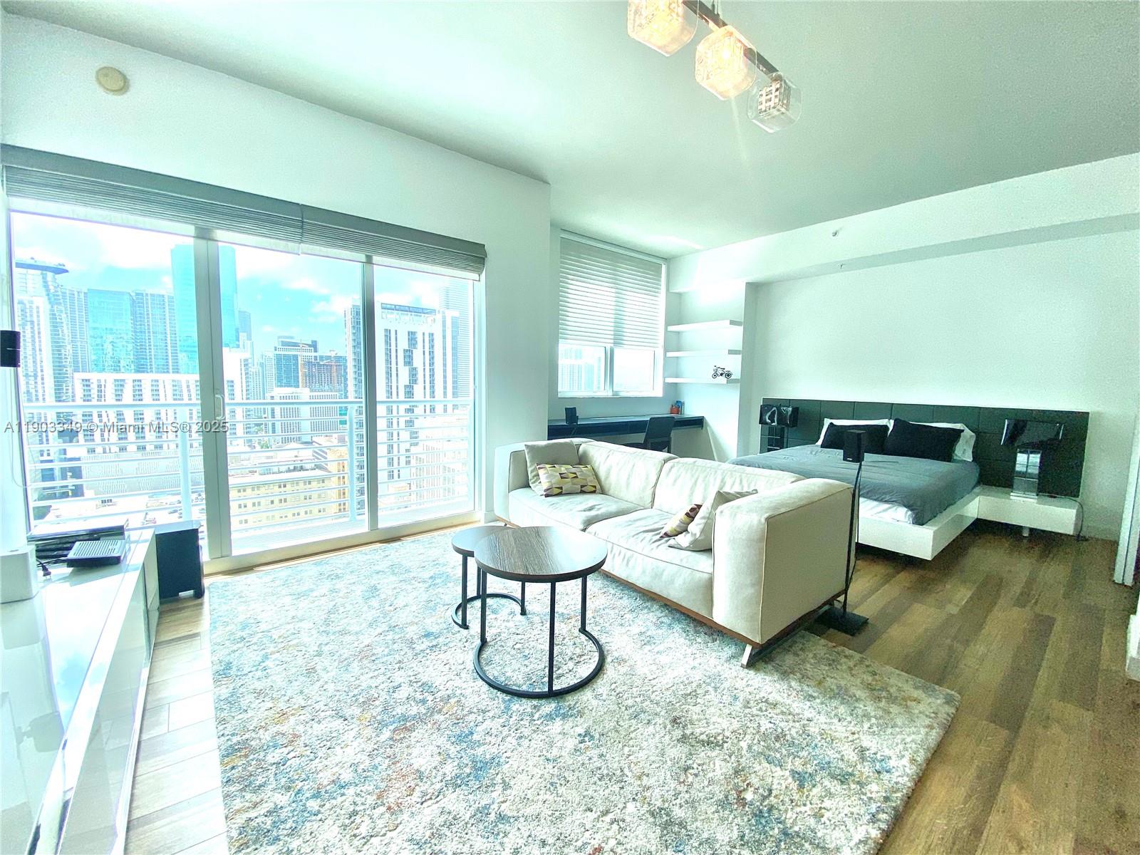 133 Northeast 2nd Avenue, Unit 2904 Miami, FL 33132 - Photo 3 of 11 a living room with furniture and a large window