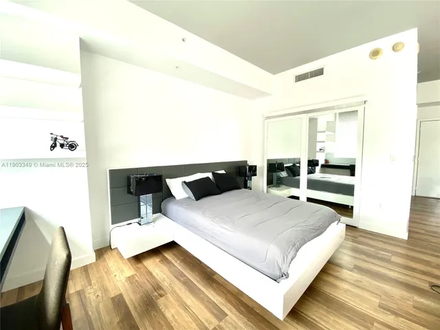 a bedroom with a bed and a night stand