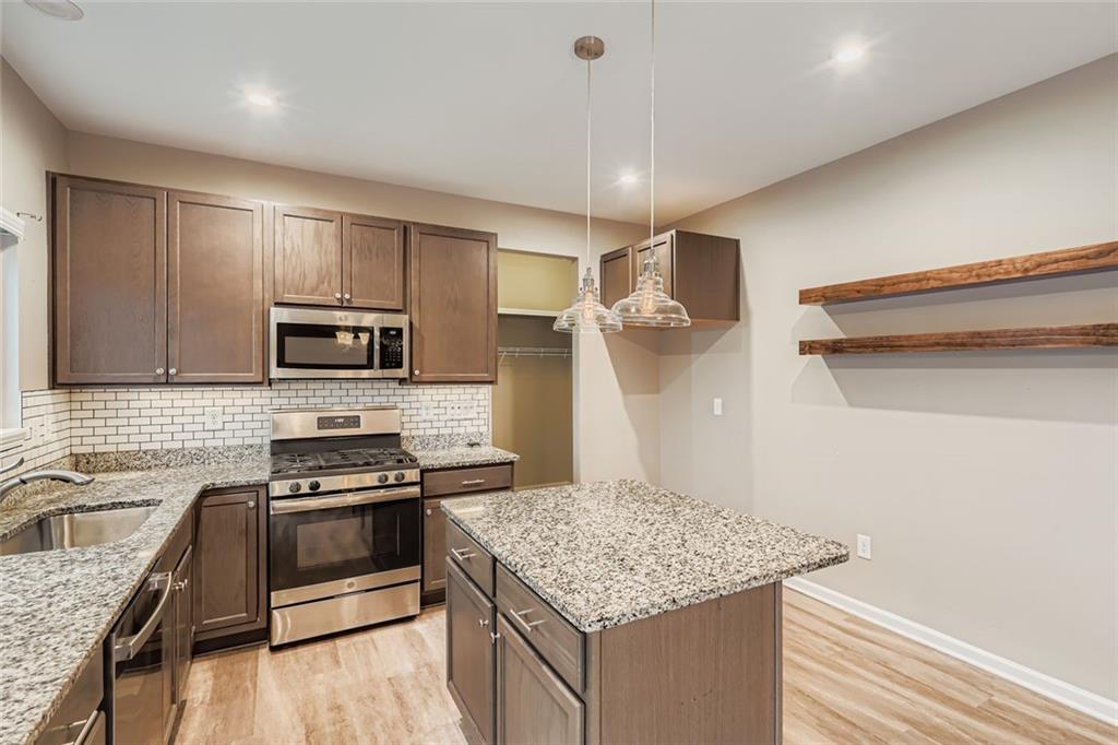 114 Greenbrier Way Canton, GA 30114 - Photo 11 of 32 a kitchen with stainless steel appliances granite countertop a sink stove and refrigerator