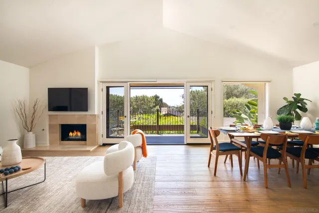 a living room with fireplace furniture and a large window