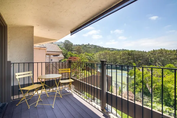 a view of a balcony with chairs and wooden floor
