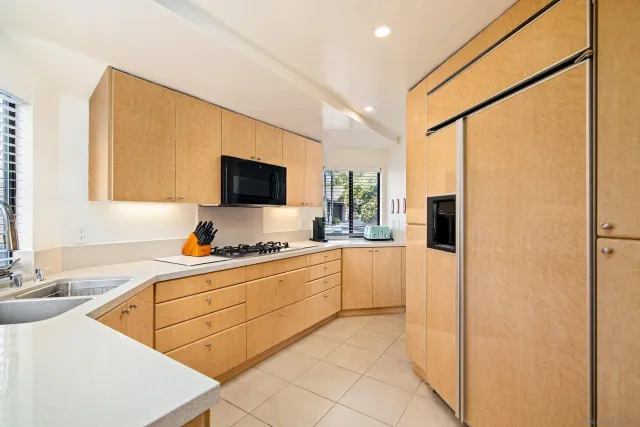 a kitchen with stainless steel appliances a sink cabinets and a large window
