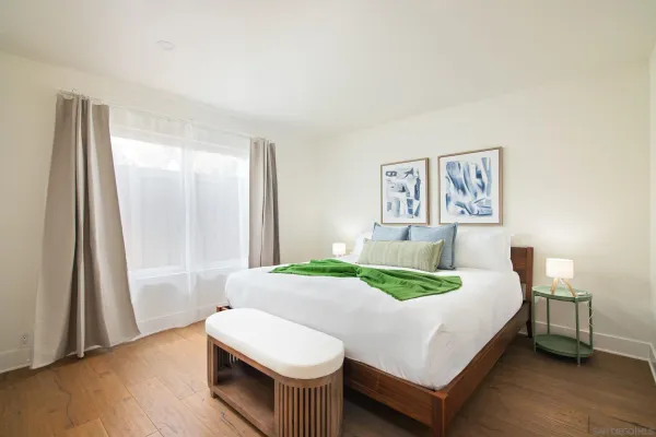 a bed sitting in a bedroom next to a window