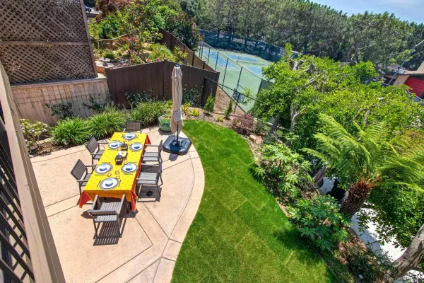 a view of a chair and table in backyard with potted plants