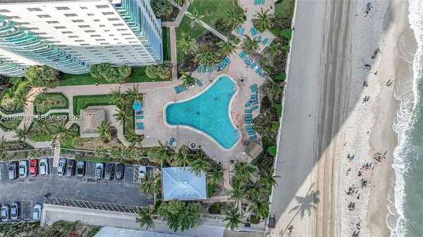 an aerial view of a swimming pool with outdoor seating and plants