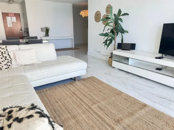 a living room with furniture and a potted plant