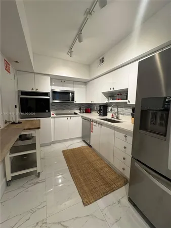 a kitchen with cabinets and steel appliances