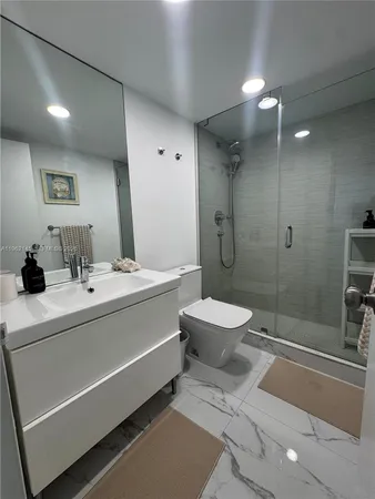 a bathroom with a sink a toilet and shower