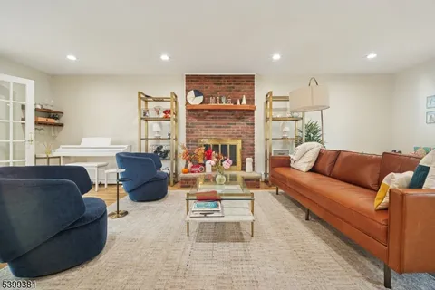 a living room with furniture a wooden floor and a potted plant