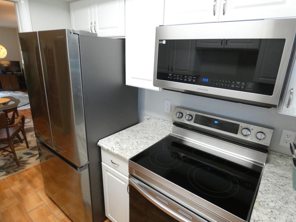 1701 Pinehurst Road, Unit 9G Dunedin, FL 34698 - Photo 3 of 22 a kitchen with granite countertop cabinets and steel stainless steel appliances